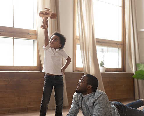 Father and son playing with a wooden plane